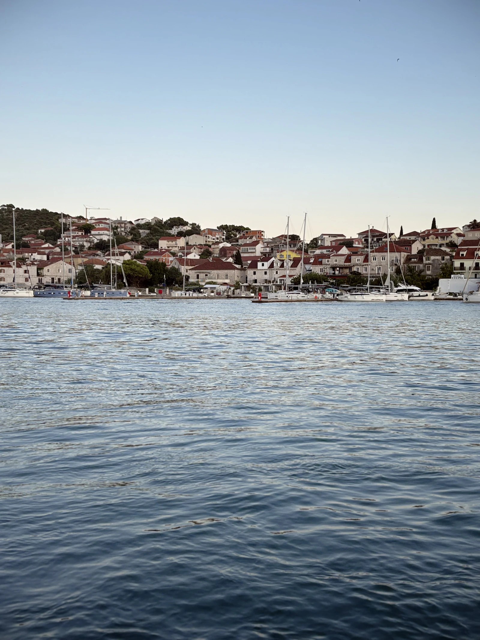 Paseo marítimo de Trogir con edificios de piedra y barcos amarrados