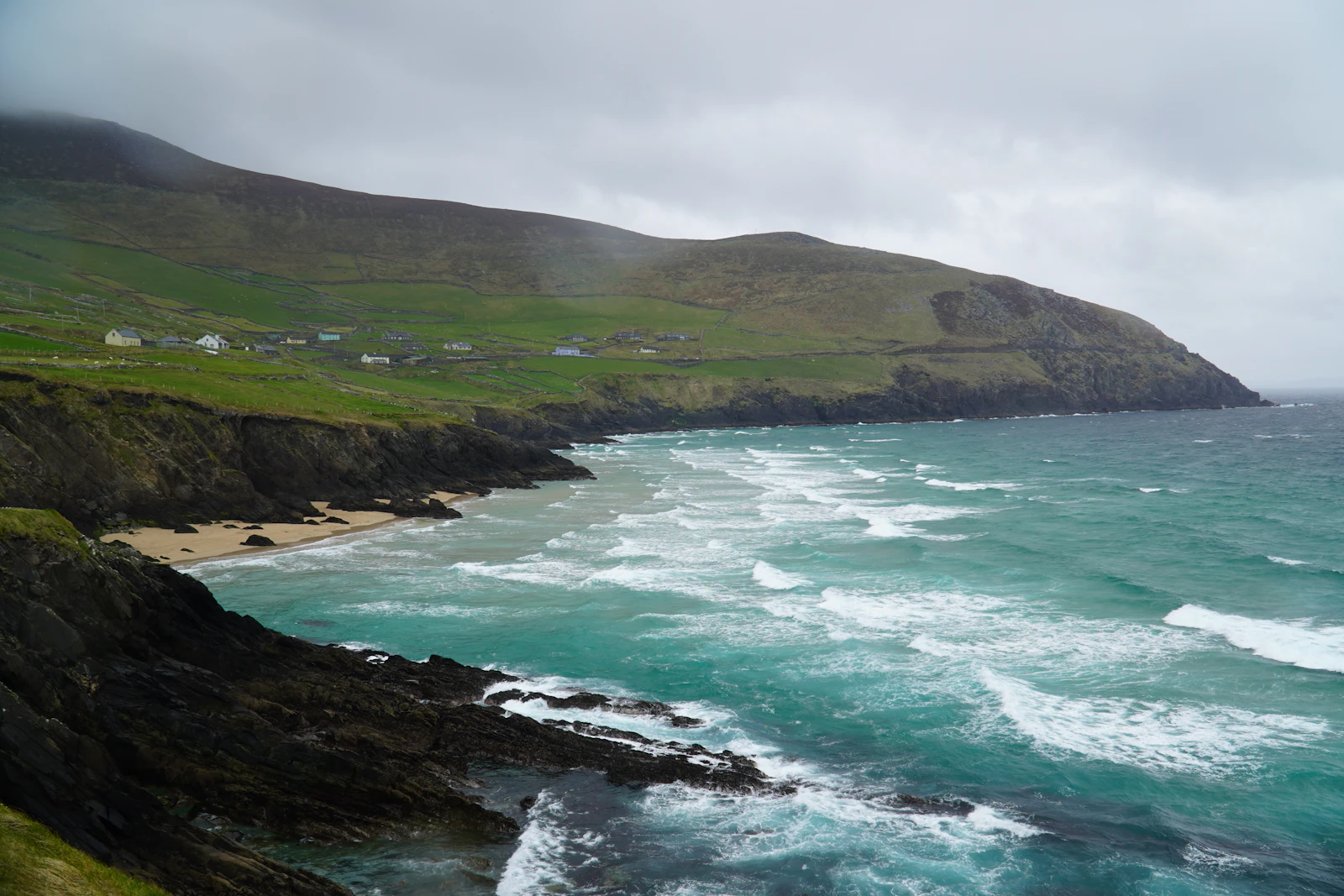 Carretera costera entre acantilados verdes y el océano Atlántico en la península de Dingle