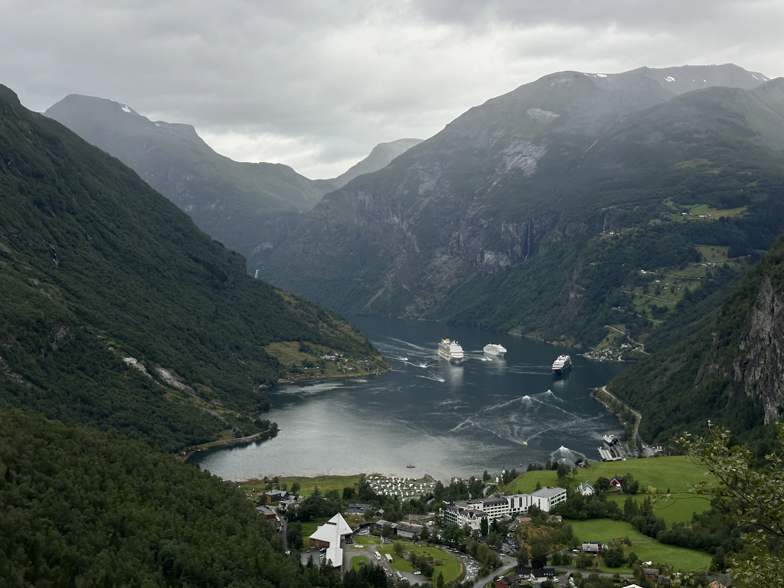 Pueblo de Geiranger al fondo del fiordo, rodeado de montañas verdes